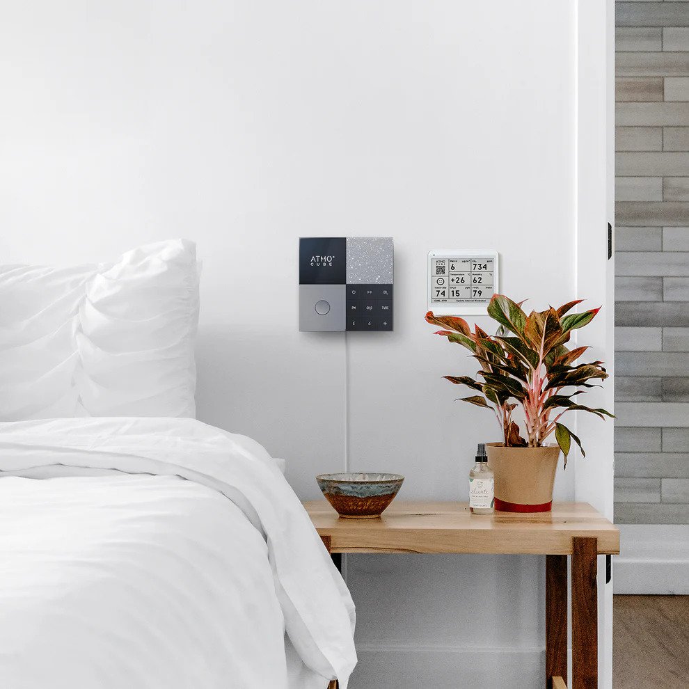 Atmocube smart indoor air quality monitor wall mounted in bedroom