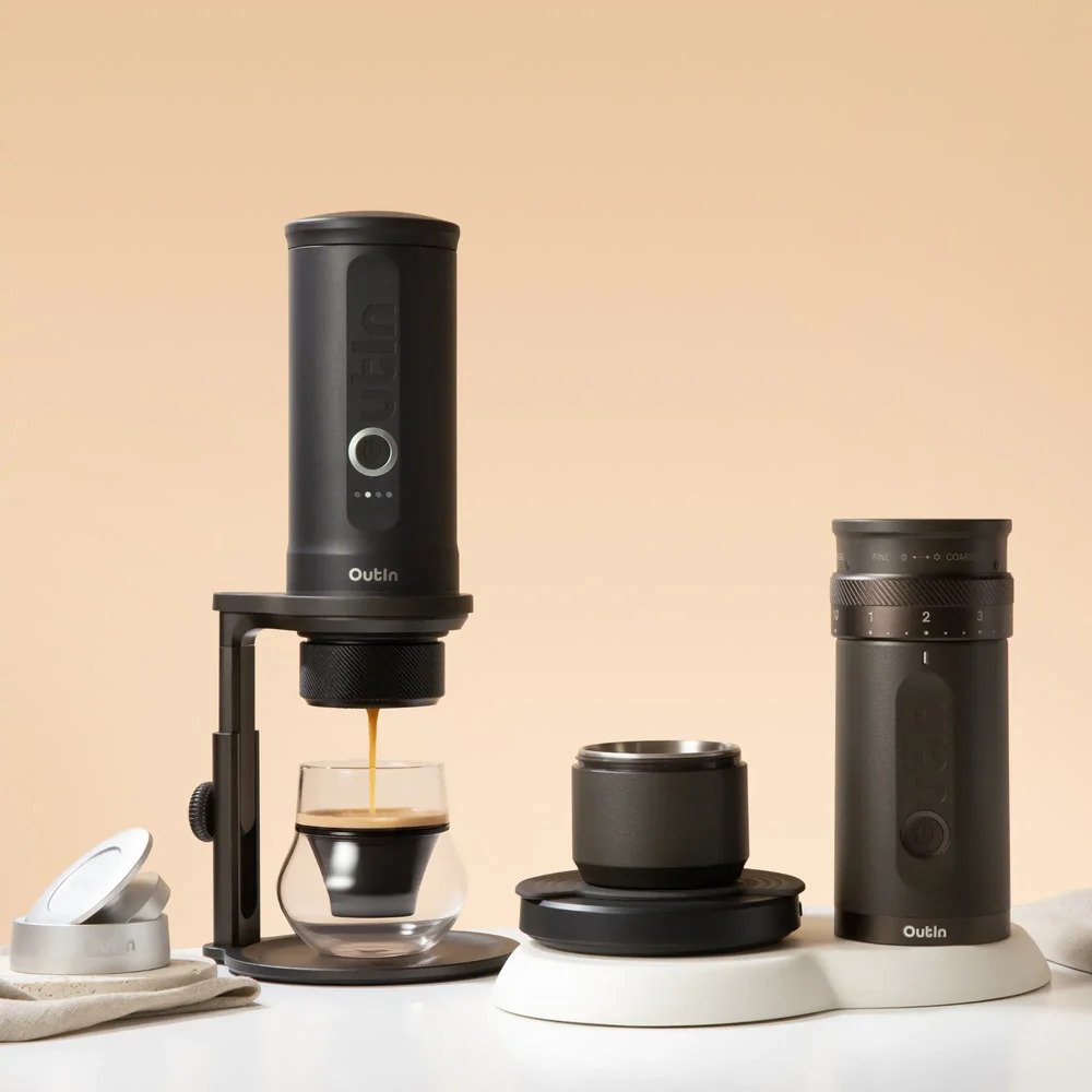 All-in-one coffee station setup featuring OutIn portable electric coffee grinder, coffee beans, grinder output, and brewing tools for home and travel use