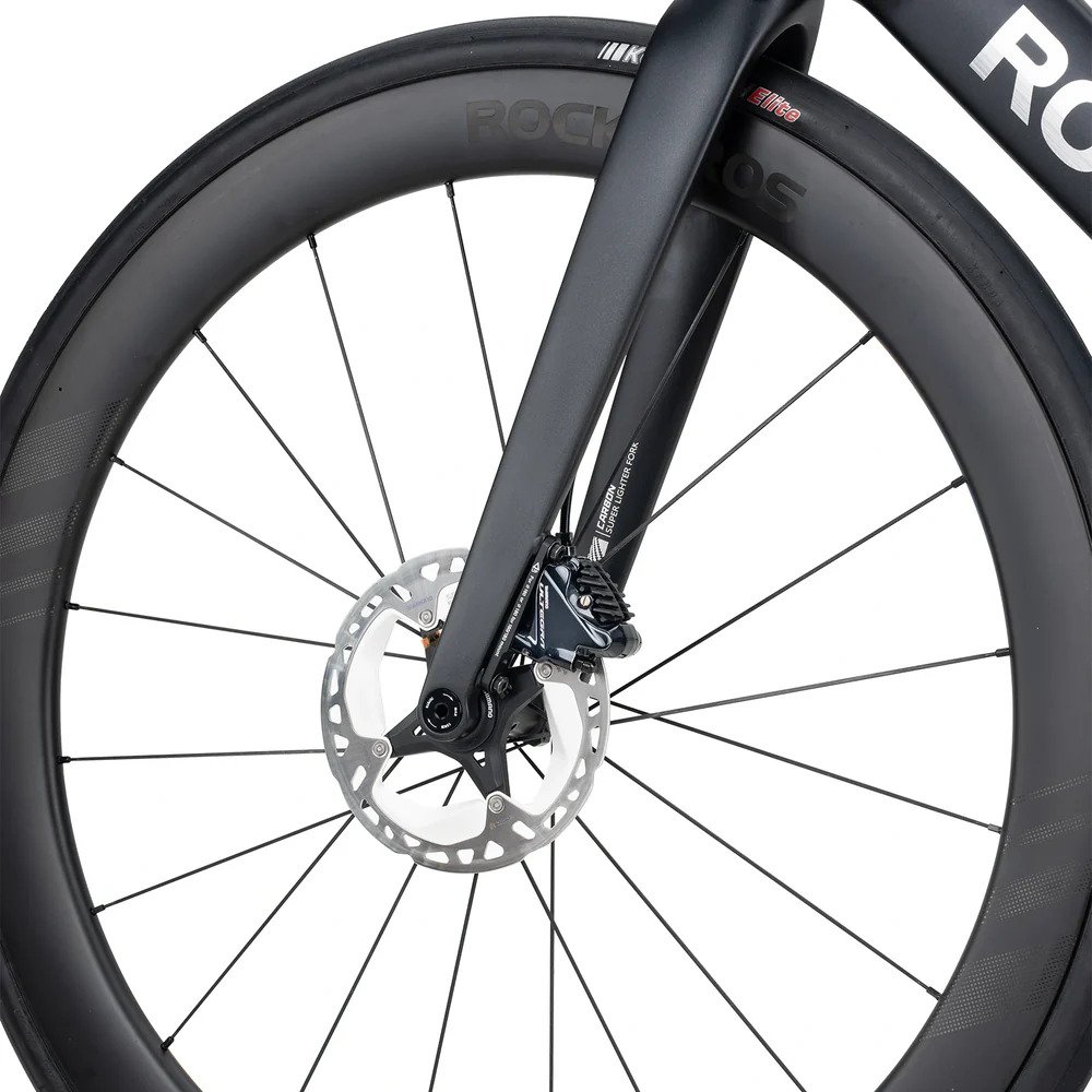 close up of road bike wheel braking system with brake caliper and rim